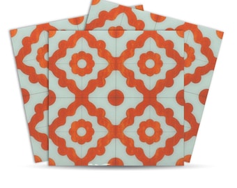 May include: Square decorative tiles with a repeating orange floral pattern on a light blue background. The design features a central flower shape surrounded by four symmetrical floral motifs, creating a geometric and artistic look. The tiles are arranged in a fan-like display.