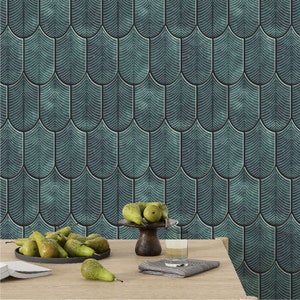 May include: A table setting with a bowl of pears on a wooden table in front of a teal green wall with a scale pattern.