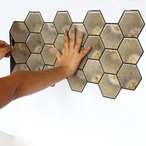 Light brown hexagon peel-and-stick tile sheet for kitchen backsplash; wood-look honeycomb pattern, self-adhesive vinyl tile.