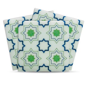 Puede incluir: Un conjunto de baldosas decorativas cuadradas con un patrón de estrellas geométricas repetidas. El diseño presenta estrellas de ocho puntas en tonos verdes y azules, delineadas en tonos más oscuros, sobre un fondo blanco. Las baldosas probablemente son de cerámica o un material similar.