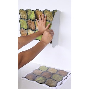 3D peel-and-stick wall tile grid with scalloped square tiles in moss green, brown, and tan for an earthy kitchen backsplash.