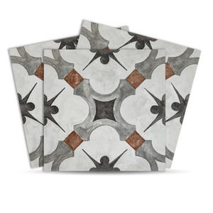May include: A stack of square tiles with a repeating pattern. The design features grey, brown, and black geometric shapes on a white background. The tiles have a slightly distressed, watercolour-like appearance.
