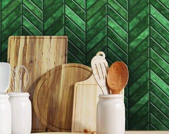 May include: A collection of wooden cutting boards and kitchen utensils, including a round board, a rectangular board, a spoon, and a spatula. The items are arranged on a wooden countertop in front of a green chevron patterned wall.