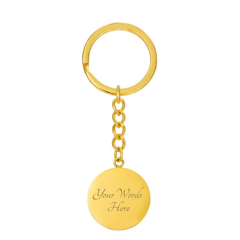 May include: A gold-coloured keyring with a round pendant. The pendant has the text "Your Words Here" engraved on it. The keyring includes a ring and a chain of small links.