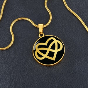 Puede incluir: Collar de oro con un colgante negro que presenta un símbolo de infinito entrelazado con un corazón.