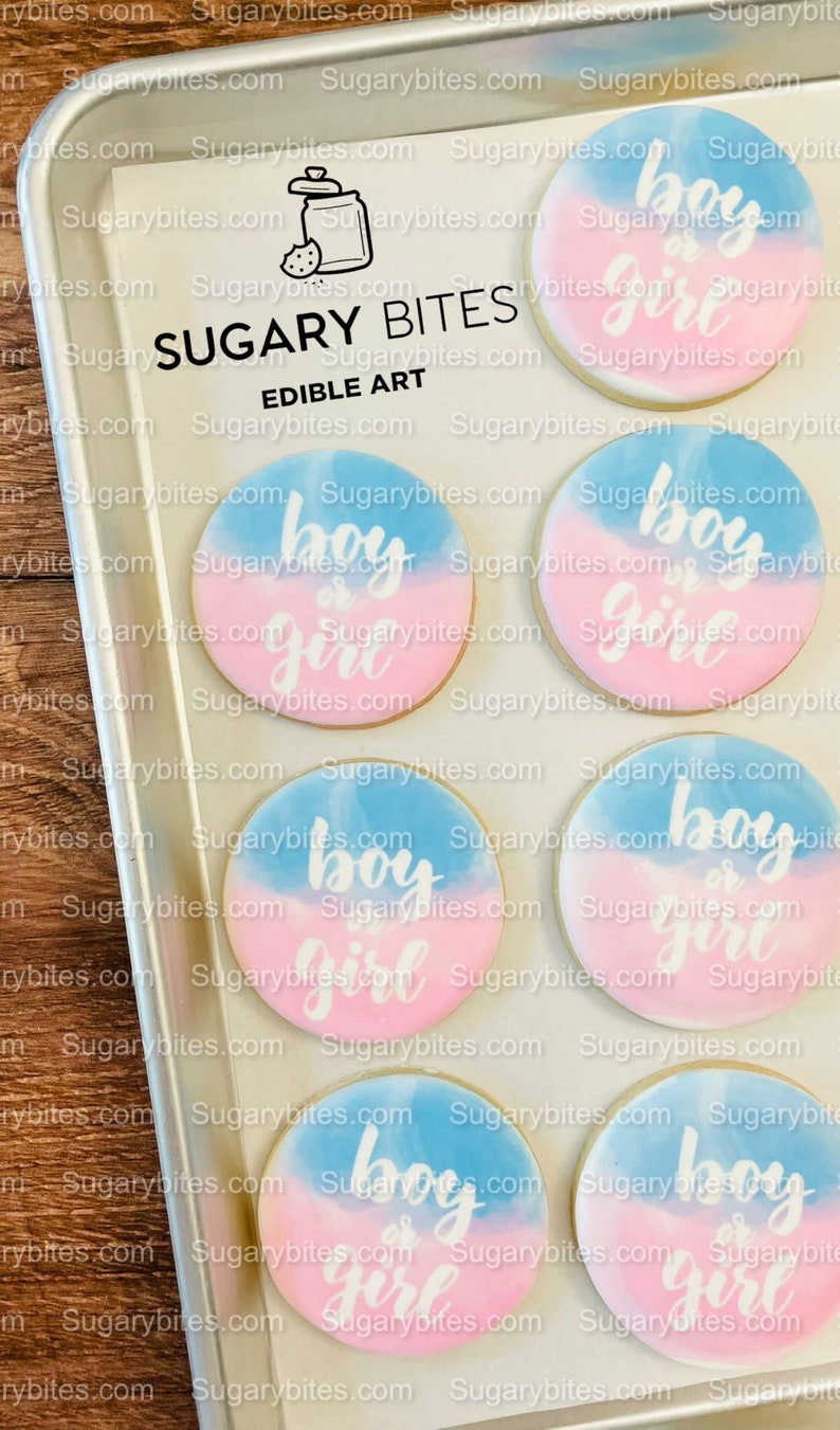 May include: Six round sugar cookies decorated with a blue and pink watercolour design. The cookies are decorated with white icing and the words "boy or girl" on each cookie.