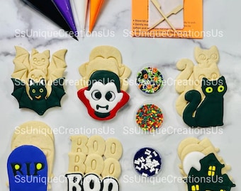 May include: A Halloween cookie decorating kit with six different cookie designs: a bat, a vampire, a cat, a tombstone, a ghost, and a haunted house. The kit includes four bags of icing, four containers of sprinkles, and two wooden sticks.