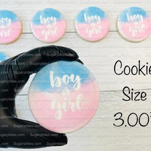 May include: Four decorated sugar cookies with blue and pink icing and the text "boy or girl" in white. A gloved hand holds a similar cookie in the centre of the image. The text "Cookie Size 3.00" is printed below the cookies.