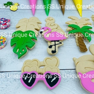 May include: A set of cookie cutters featuring a variety of tropical themes, including palm trees, monstera leaves, sunglasses, and flamingos. The cutters are made of metal and are perfect for creating fun and festive cookies.