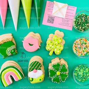 Può includere: Un set di sei biscotti di zucchero decorati con vari temi del giorno di San Patrizio, tra cui un pentolone d'oro, un trifoglio, un arcobaleno, un gnomo e un bacio. I biscotti sono disposti su una superficie verde con ciotole di zuccherini verdi, arancioni e gialli.