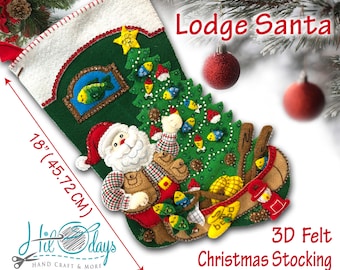 Op de afbeelding: Een 45,72 cm lange 3D-vilt kerstsok met een kerstman- en visserijthema. De groene sok heeft een witte manchet en rode details. De tekst "Lodge Santa" en "3D Felt Christmas Stocking" zijn zichtbaar.