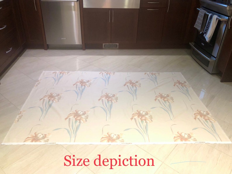 May include: A beige area rug with a floral pattern featuring brown and blue irises. The rug is laid out on a tiled floor in a kitchen.