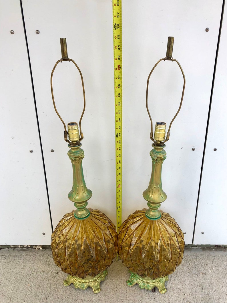 Pu&ograve; includere: Una coppia di lampade da tavolo con basi in vetro ambrato a coste e steli e basi in metallo dai toni verdi. Un metro a nastro giallo &egrave; posizionato tra le lampade, indicando un'altezza di circa 96,5 cm dalla base alla punta superiore.