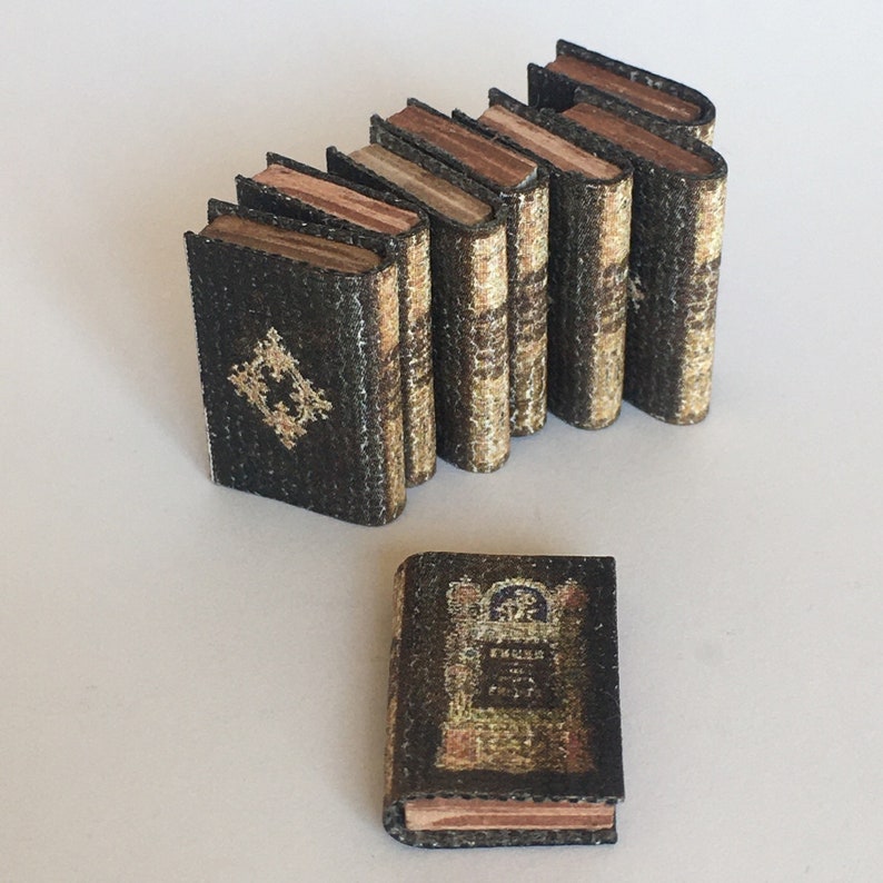 May include: A stack of eight miniature books with brown covers and gold accents. The books are arranged in a staggered formation. The top book has the title "ENGLISH POETS" printed on the cover.