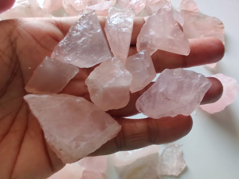 Pu&ograve; includere: Una collezione di cristalli di quarzo rosa, alcuni con un aspetto pi&ugrave; opaco, altri con una qualit&agrave; traslucida. I cristalli sono grezzi e non levigati, con bordi e punte naturali.