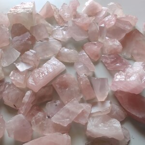 Pu&ograve; includere: Una collezione di cristalli di quarzo rosa, ognuno con una forma e una dimensione uniche. I cristalli sono grezzi e non lucidati, con una texture naturale e ruvida.