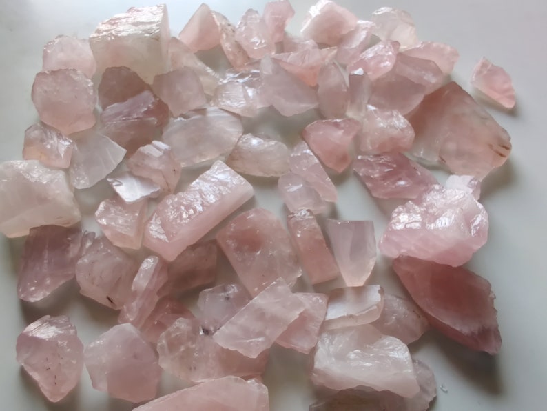Pu&ograve; includere: Una collezione di cristalli di quarzo rosa, ognuno con una forma e una dimensione uniche. I cristalli sono grezzi e non lucidati, con una texture naturale e ruvida.