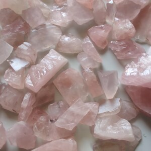 Pu&ograve; includere: Una collezione di cristalli di quarzo rosa di varie dimensioni e forme. I cristalli sono traslucidi e hanno una texture naturale e ruvida.