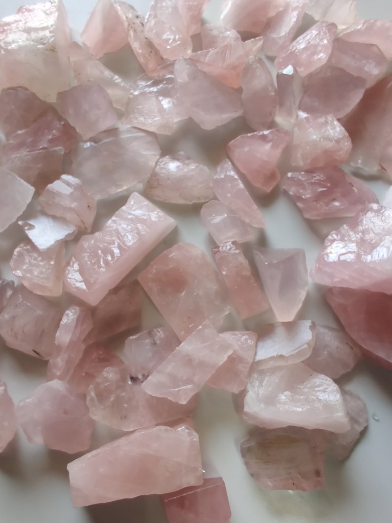 Pu&ograve; includere: Una collezione di cristalli di quarzo rosa di varie dimensioni e forme. I cristalli sono traslucidi e hanno una texture naturale e ruvida.