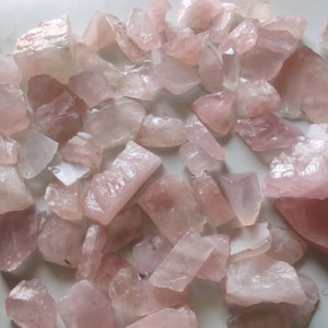 Pu&ograve; includere: Una collezione di cristalli di quarzo rosa, di varie forme e dimensioni. I cristalli sono grezzi e non levigati, con una texture naturale e ruvida.