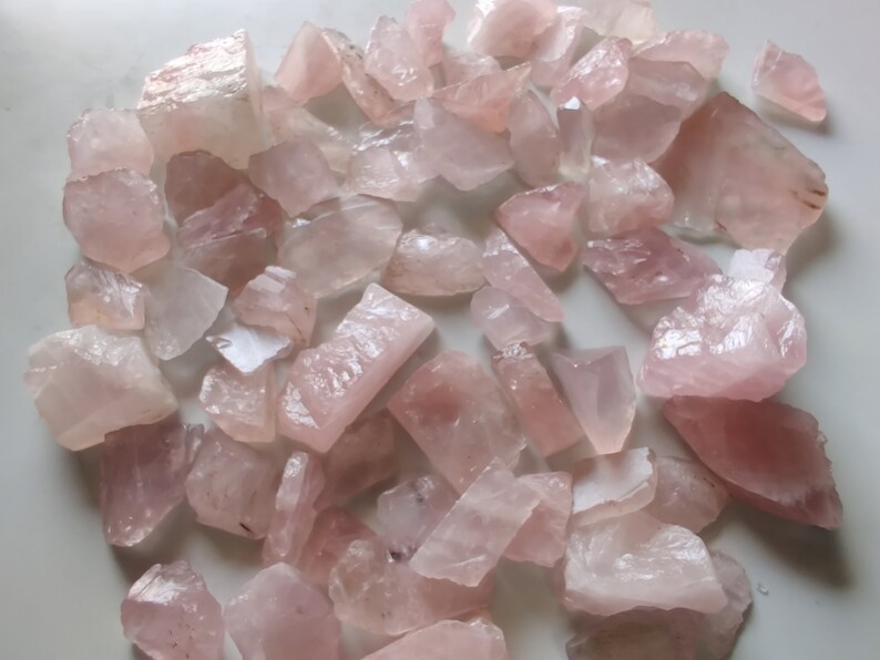 Pu&ograve; includere: Una collezione di cristalli di quarzo rosa, di varie forme e dimensioni. I cristalli sono grezzi e non levigati, con una texture naturale e ruvida.