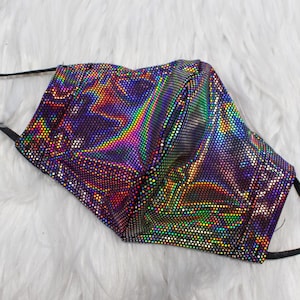 May include: A black face mask with a holographic iridescent pattern. The mask has adjustable ear loops.