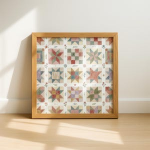 Könnte beinhalten: Ein quadratisches Wandbild in einem hellen Holzrahmen mit einem Raster aus aquarellartigen Quilt-Blöcken. Das Muster zeigt verschiedene geometrische Stern- und Quadratmotive in gedeckten Rot-, Blau-, Grün- und Gelbtönen, die durch kleine Blumenmotive getrennt sind.
