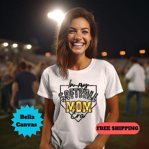 May include: White t-shirt with a black and white graphic of a baseball diamond with the text "In my Softball Mom Era".