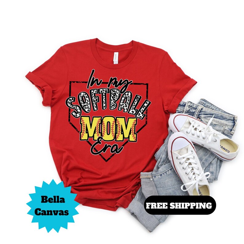 May include: Red t-shirt with a white and black leopard print softball design inside a red baseball diamond. The text "In my Softball Mom Era" is written in yellow and black.