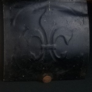 May include: Three vintage metal wall panels with a fleur-de-lis design. The panels are painted white, silver, and black.