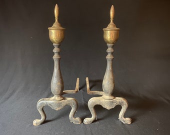 Antique cast iron andirons with brass finials.