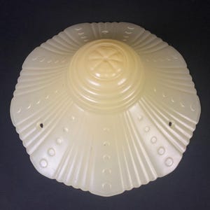 May include: A white, scalloped glass lampshade with a raised, circular design in the center.