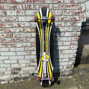 May include: A vintage skateboard with a black base, accented by yellow and white stripes. The board features red wheels and silver hardware. The text "Rule Out Drugs / Just Say NO!" is visible on the board.