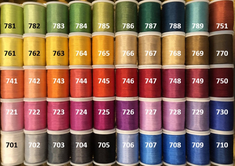 May include: A collection of 100 spools of thread in various colors, numbered 701 to 799. The spools are arranged in rows of ten, with each row containing a different color.
