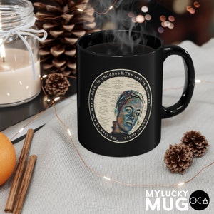May include: Black ceramic mug with a white circle design featuring a portrait of a person and the text "We look at the world once, in childhood. The rest is memory."  "Louise Gl&uuml;ck"