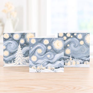 Pack of three Van Gogh inspired Christmas cards featuring snowy winter scenes with swirling blue skies and warm golden stars.