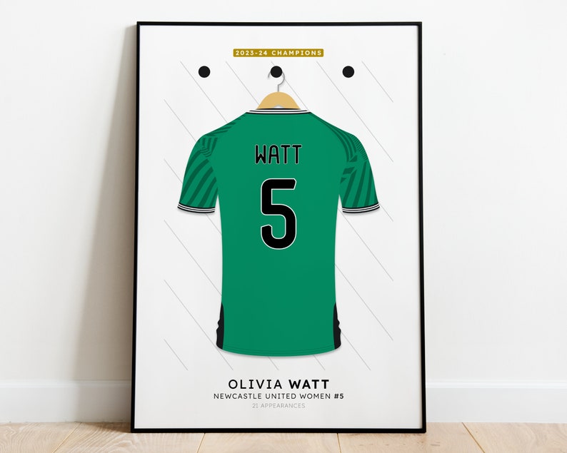 Pu&ograve; includere: Una maglia da calcio verde con strisce bianche e nere sulle maniche. La maglia ha il nome "WATT" e il numero "5" sul retro. Il testo "OLIVIA WATT NEWCASTLE UNITED WOMEN #5 21 APPEARANCES" &egrave; stampato sotto la maglia.