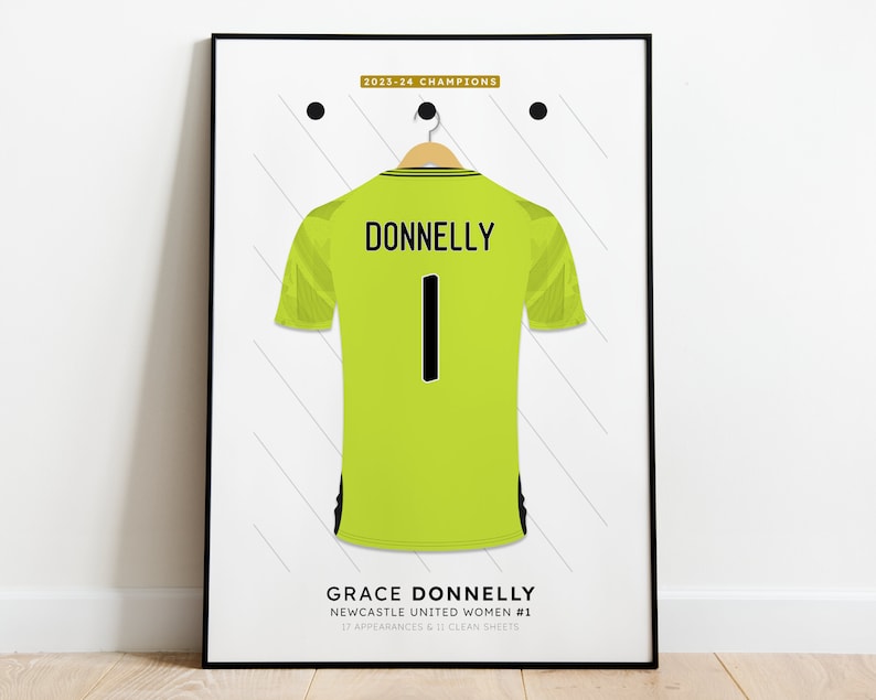 Pu&ograve; includere: Una maglia da calcio verde con bordi neri e il nome "DONNELLY" e il numero "1" sul retro. Il testo "GRACE DONNELLY" e "NEWCASTLE UNITED WOMEN #1" &egrave; sotto la maglia. Il testo "17 APPEARANCES & 11 CLEAN SHEETS" &egrave; sotto il nome.