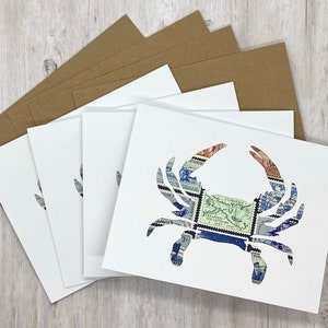 May include: Set of five blank white note cards with a blue and white crab design made from vintage postage stamps. The cards are packaged with brown envelopes.