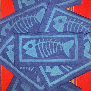 May include: A stack of blue fabric squares with a white outline and a blue fishbone design printed on each square.