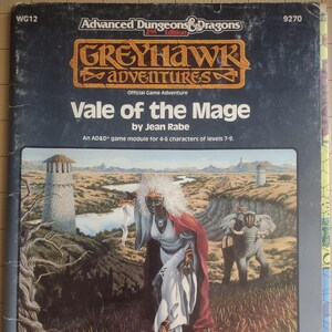 May include: A vintage Advanced Dungeons & Dragons Greyhawk Adventures game module titled "Vale of the Mage" by Jean Rabe. The cover art features a fantasy scene with a robed figure, elephants, and towers. The module is designed for 4-6 characters of levels 7-9.