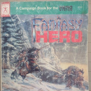 May include: A book cover for a fantasy role-playing game called "Fantasy Hero" with a snowy landscape illustration featuring a warrior on horseback and a large, furry creature. The book is a campaign book for the Hero System.
