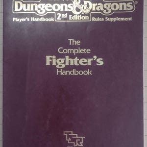 May include: A purple Advanced Dungeons & Dragons 2nd Edition Player's Handbook Rules Supplement. The cover features gold lettering that reads "Advanced Dungeons & Dragons" and "The Complete Fighter's Handbook". The TSR, Inc. logo is at the bottom.