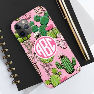 May include: A pink phone case with a white monogram "ABC" in a circle. The case is covered in a pattern of green cacti and pink flowers.