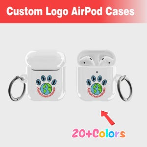 Puede incluir: Funda blanca para AirPod con un logotipo personalizado que presenta una huella de pata con un globo terráqueo en su interior y el texto "Alpha Creative Studio". La funda tiene un anillo de metal adjunto. La imagen muestra más de 20 colores disponibles.