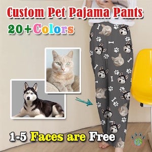 May include: Custom pet pajama pants with a gray background and a repeating pattern of paw prints and pet faces. The pants feature a variety of pet faces, including a cat, a husky, and a dog. The text "Custom Pet Pajama Pants" and "20+ Colors" is displayed at the top of the image. The text "1-5 Faces are Free" is displayed at the bottom of the image.