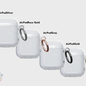 Puede incluir: Cuatro estuches de pl&aacute;stico transparente para AirPods con un anillo de metal unido a cada estuche. Los estuches est&aacute;n etiquetados como "AirPodSilver", "AirPodRose Gold", "AirPodGray" y "AirPodGold".