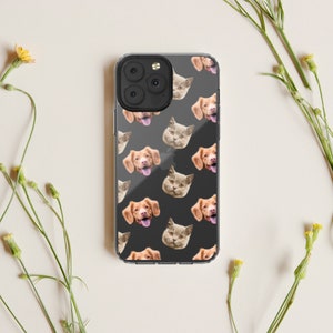 May include: A clear phone case with a repeating pattern of dog and cat faces. The case is black and the faces are in shades of brown, white, and gray.