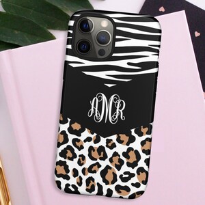 May include: A black phone case with a zebra print and leopard print design. The case has a monogram of the letters "DMR" in white.