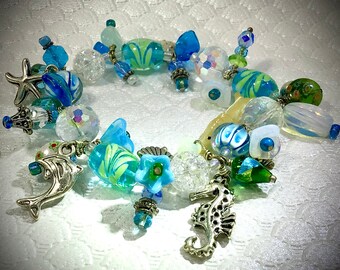 Handmade stretch charm bracelet, resort, tropical flowers, turquoise, silver, sea life starfish, shell, dolphin, seahorse, carved MOP shell